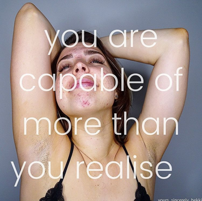 Bekki's arms are thrown behind her head in a care free manner as if she is stretching with a smile. She has brown hair, pink lips, and fair skin. The picture reads: you are capable of more than your realise.
