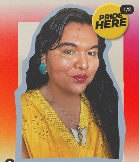 Charlie is wearing a bright yellow loose-fitting shirt, a silver butterfly necklace, turquoise circular earrings, and brownish-red lipstick. She has wavy, very long, thick, and deeply colored black hair. She sits and smiles at us gently.