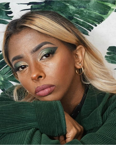 Karishma is wearing a deeply, colored green sweater - the color is regal. She wears light green and dark green eye shadow to match. She stares at us pensively.