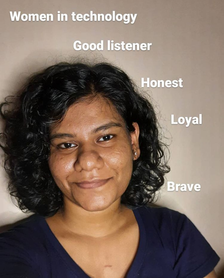 Priyanka has black hair, and her dense curls hang loosely at her shoulders. She gives a dignified and comforting smile. Words describing who she is surround her.  